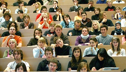 Üniversite amfisindeki sıralarda oturan ve dersi takip eden öğrenciler