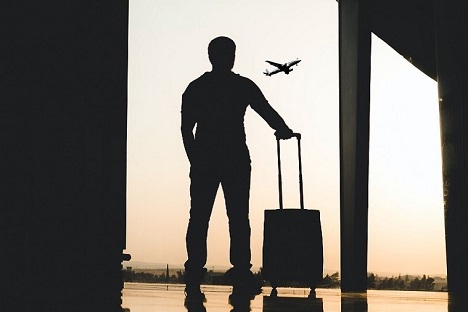 Uçak seyahatini havalimanında valiziyle bekleyen bir kişiye ait silüet
