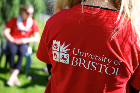 Kırmızı University of Bristol tişörtü giyen ve arkası dönük sarışın öğrenci