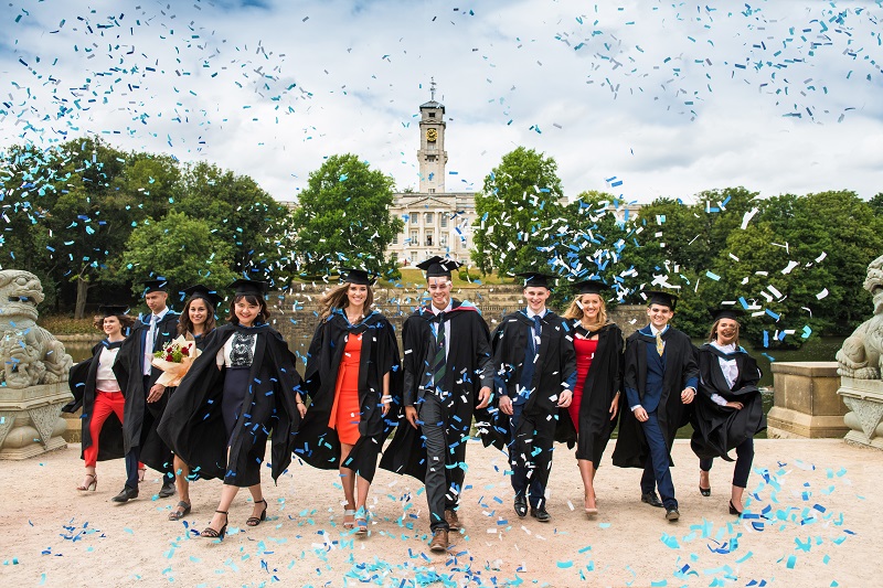 University of Nottingham University Park Kampüsü'nün önünde mezuniyetini kutlayan öğrenciler