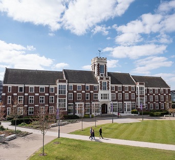 İngiltere'nin en iyi 10 Üniversitesinden biri olan Loughborough University'e ait kampüsün görüntüsü ve kampüs yolunda yürüyüş halinde olan öğrenciler